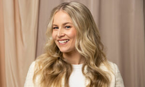 Smilende blond kvinne med sunt hår etter sommeren