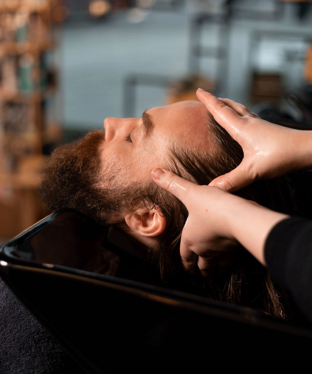 Man får huvudmassage under hårtvätt hos Nikita Hair.