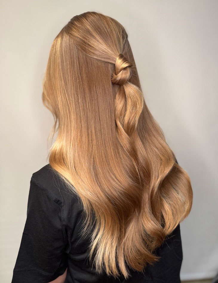 Hår i cashmere bronde med face-framing slingor i varma toner.