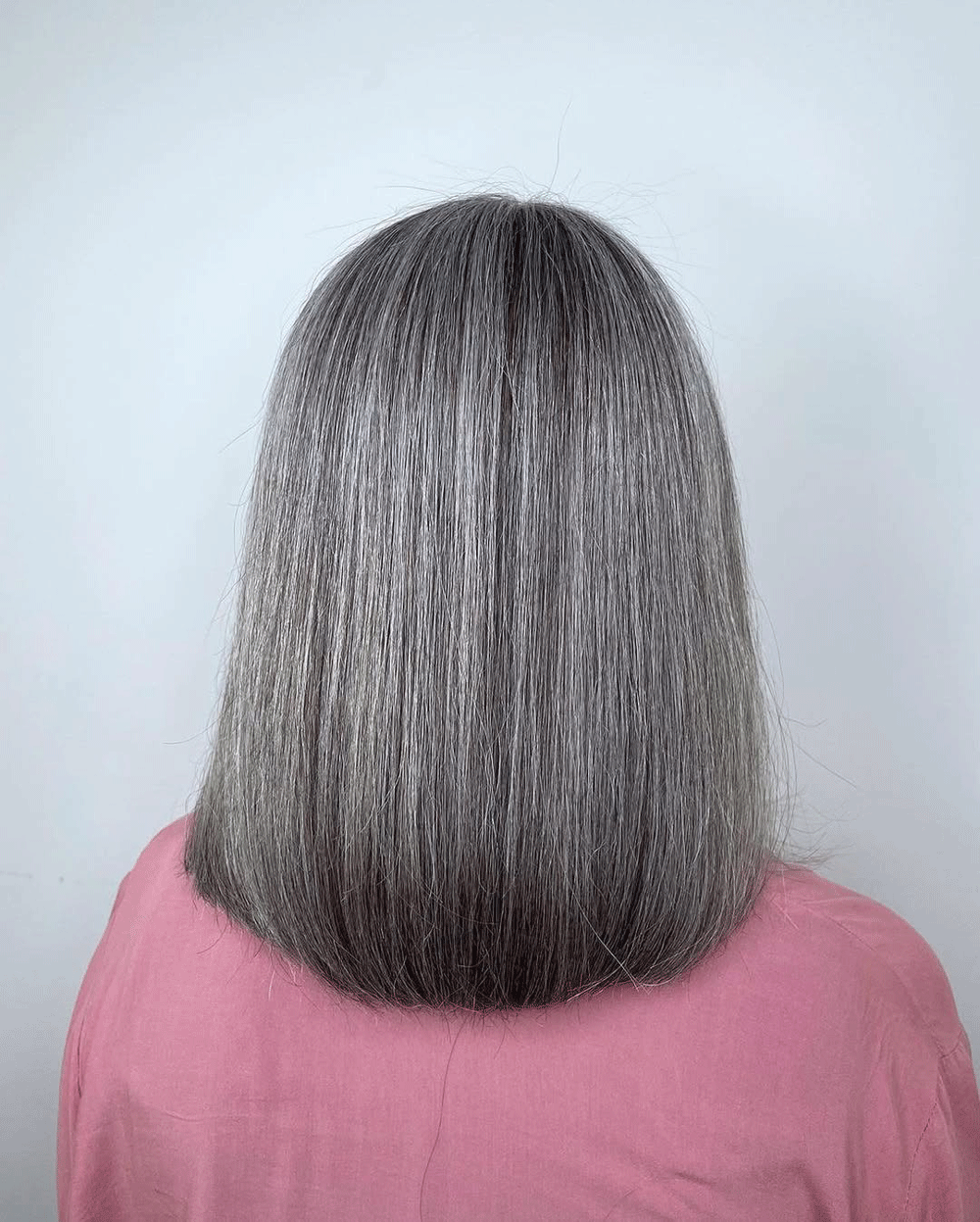 Grått hår sett bakifrån – naturligt silvergrå färg som visar hur ljus och pigment skapar en optisk illusion.