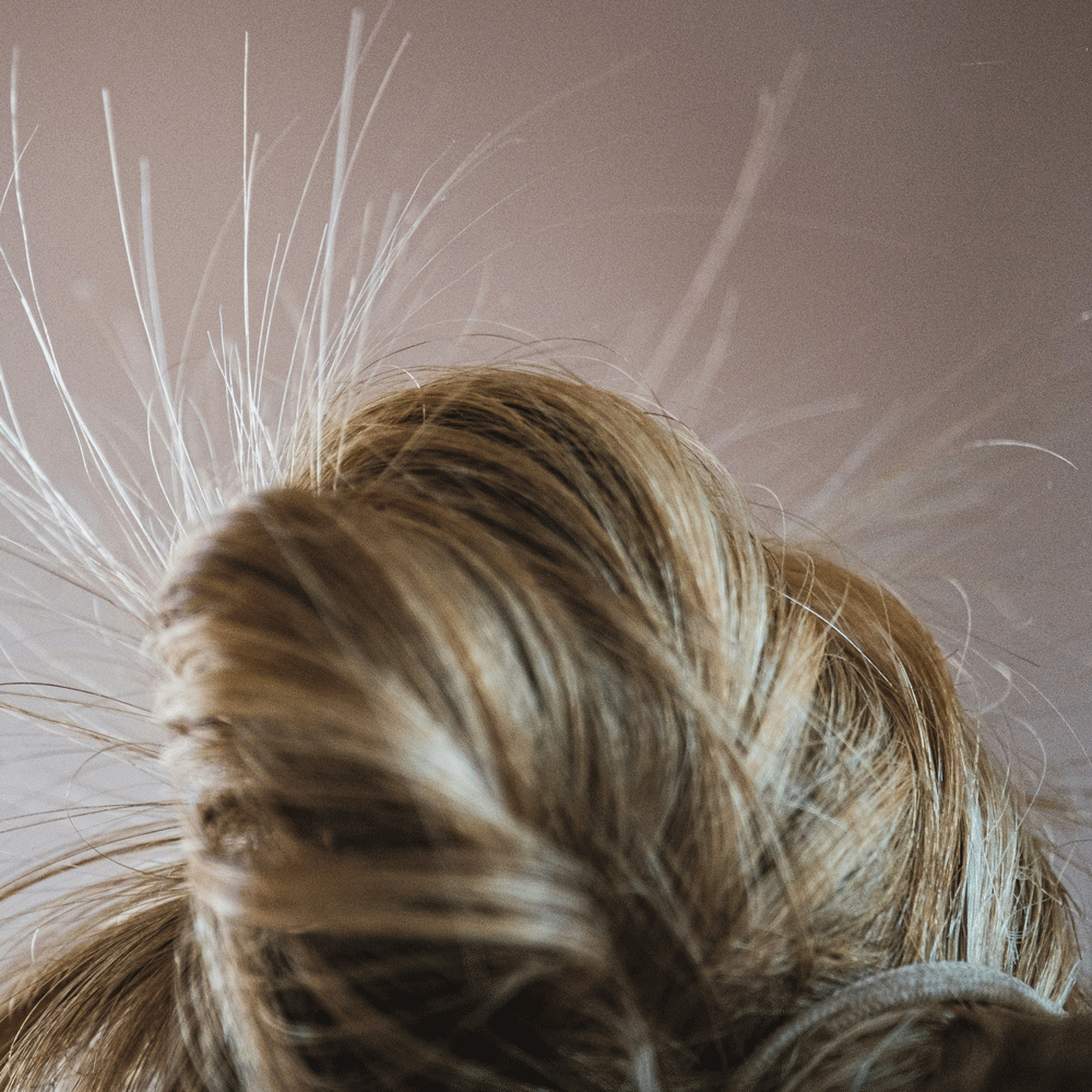 Hårstrån som står ut på grund av statisk elektricitet.