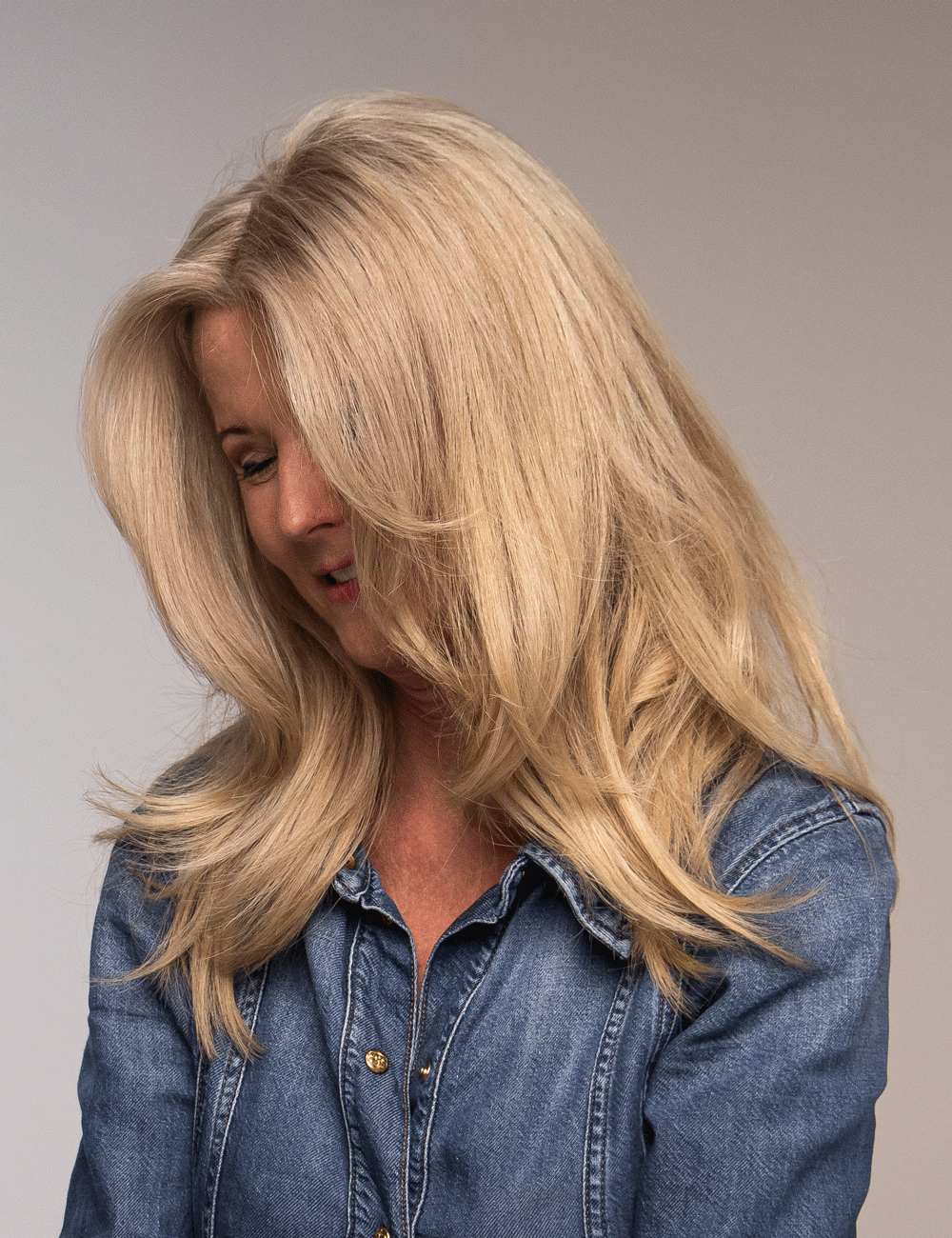 Närbild av glansig blowout frisyr med mjuk rörelse – Nikita Hair