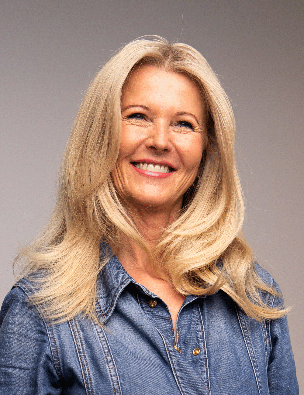 Kvinna med glansig blowout frisyr och mjuk volym – Nikita Hair