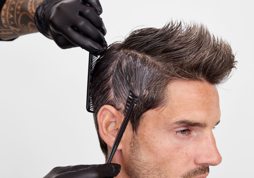 Frisør påfører hårfarge i etterveksten under Color Xpress-behandling