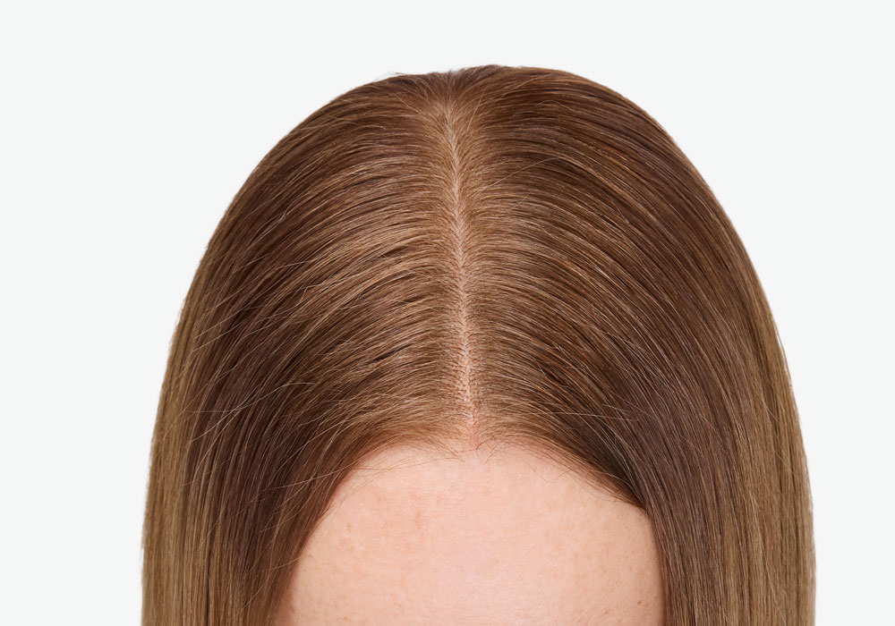 Hår etter behandling med jevn farge i skillen