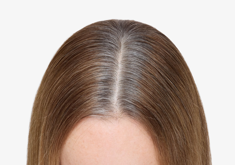 Grå ettervekst synlig i skillen før hårfargebehandling