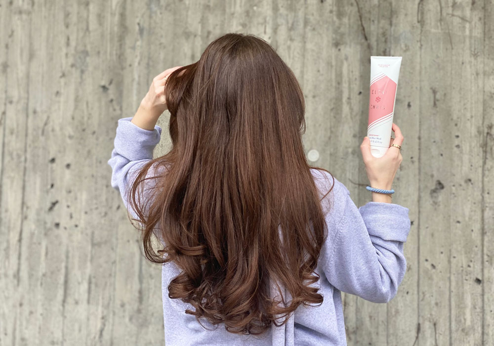 Langt, brunt hår vist bakfra med pleiende hårkurprodukt