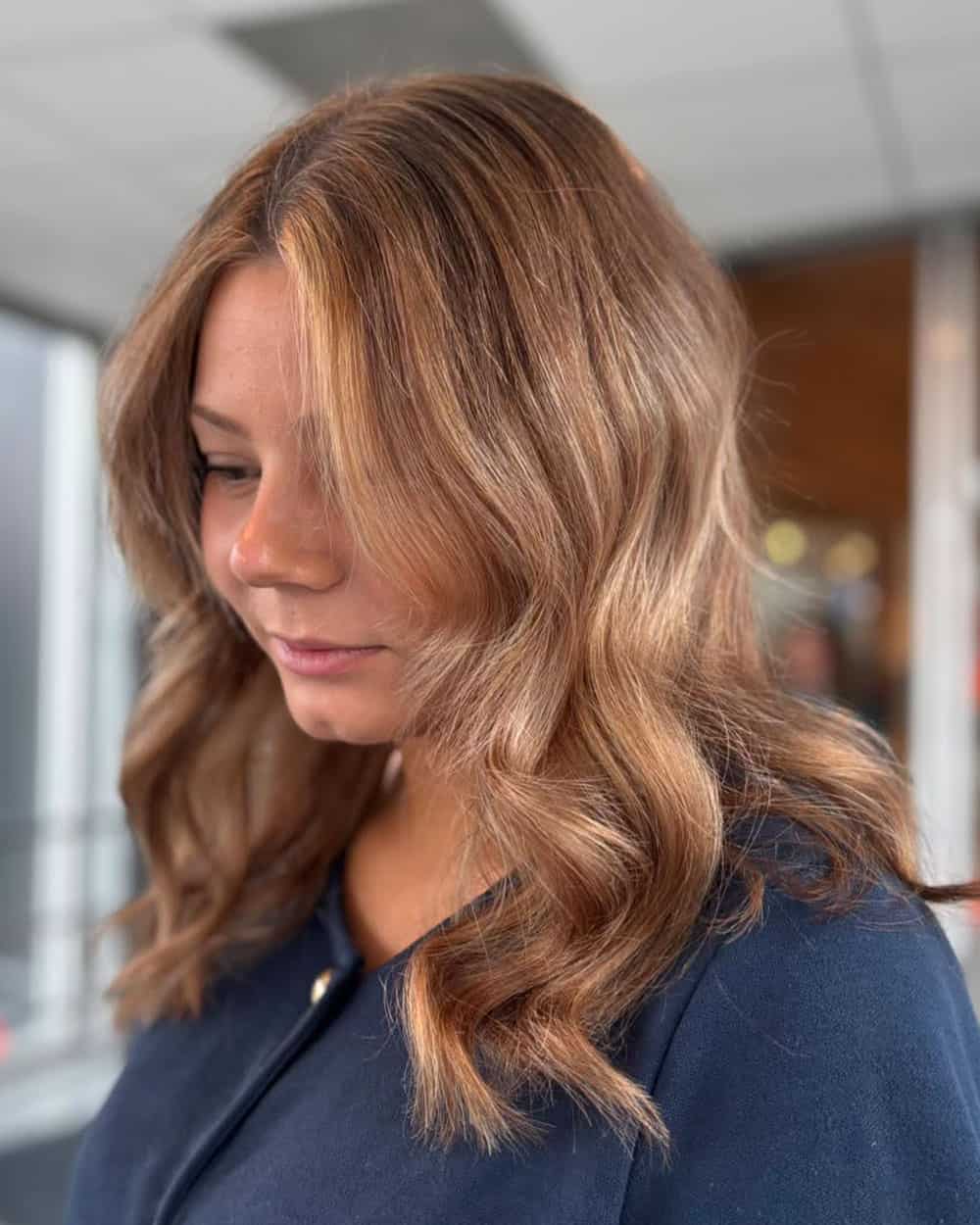 Bronde hårfärg med mjuka skiftningar i blonda, karamellfärgade och ljusbruna toner.