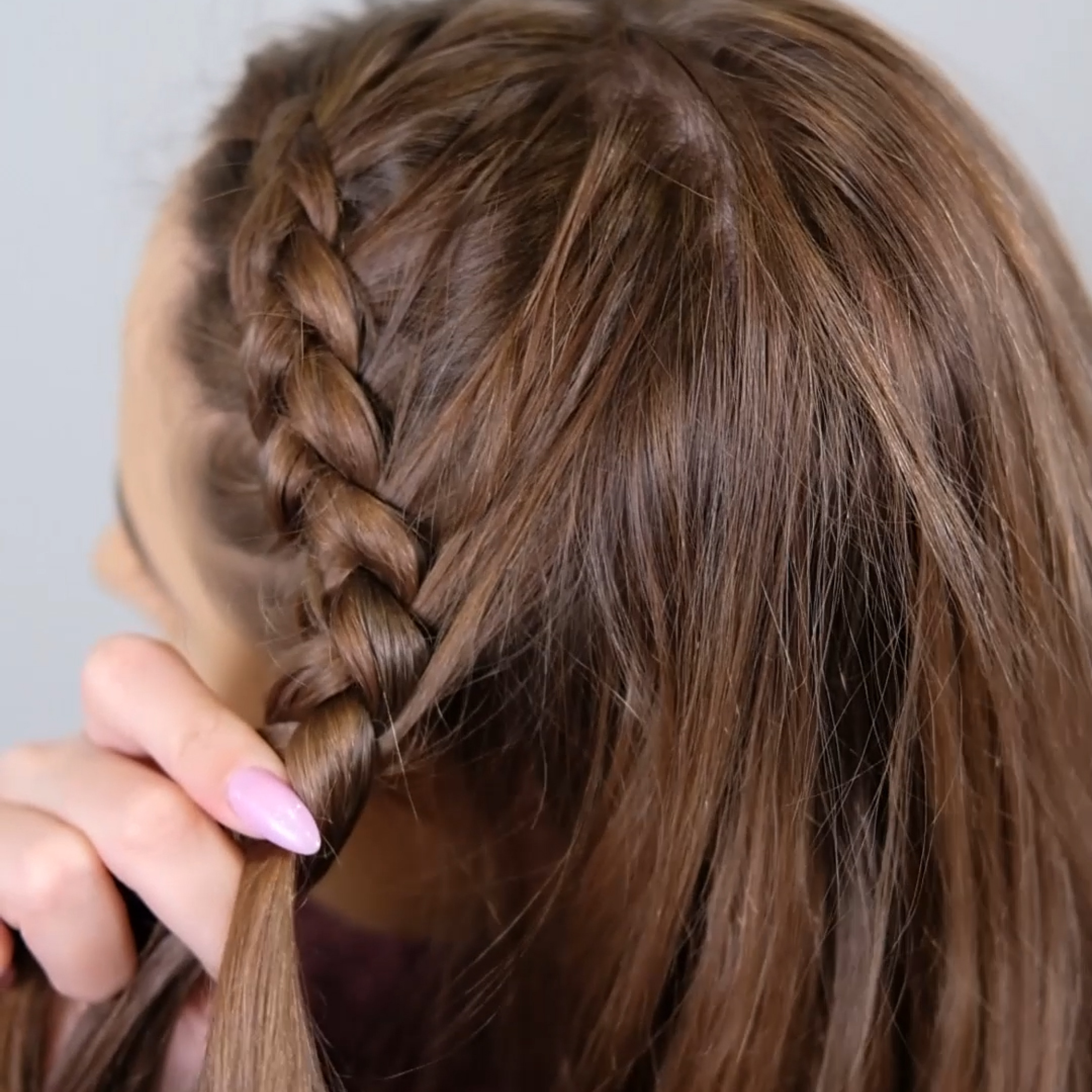Dela in håret i tre delar och fläta en dutch braid från mittbenan.